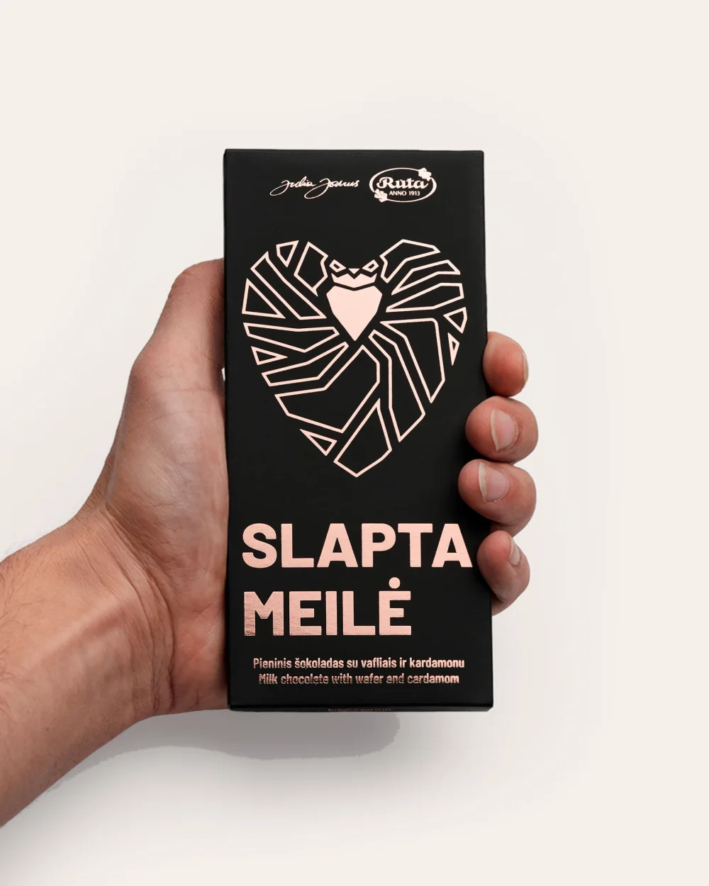 Pieninio šokolado „Slapta meilė“ juoda pakuotė su rausva širdimi rankoje