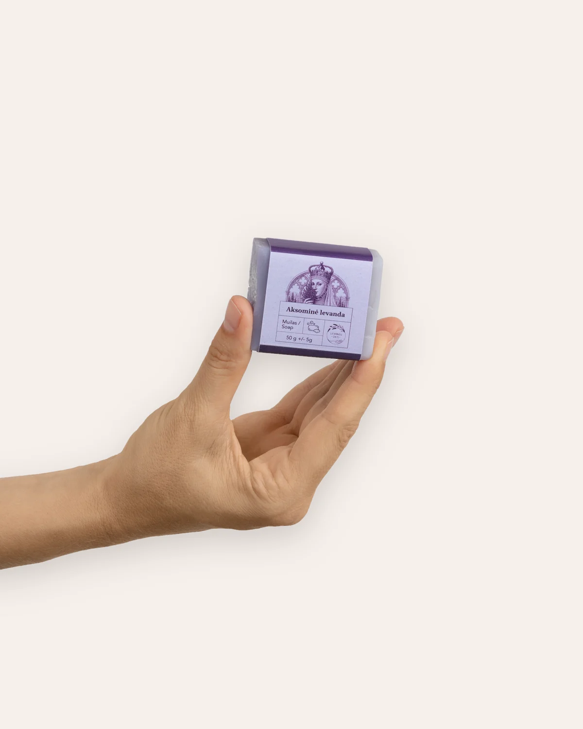 Ranka laiko mažą kieto muilo „Aksominė levanda“ 50 g gabalėlį