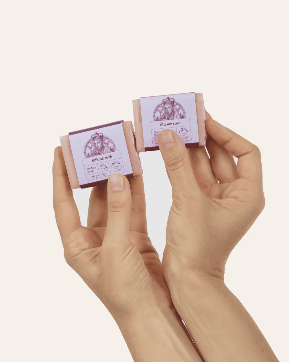 Dvi rankos laiko du mažus kieto muilo „Šilkinė rožė“ 50 g gabalėlius