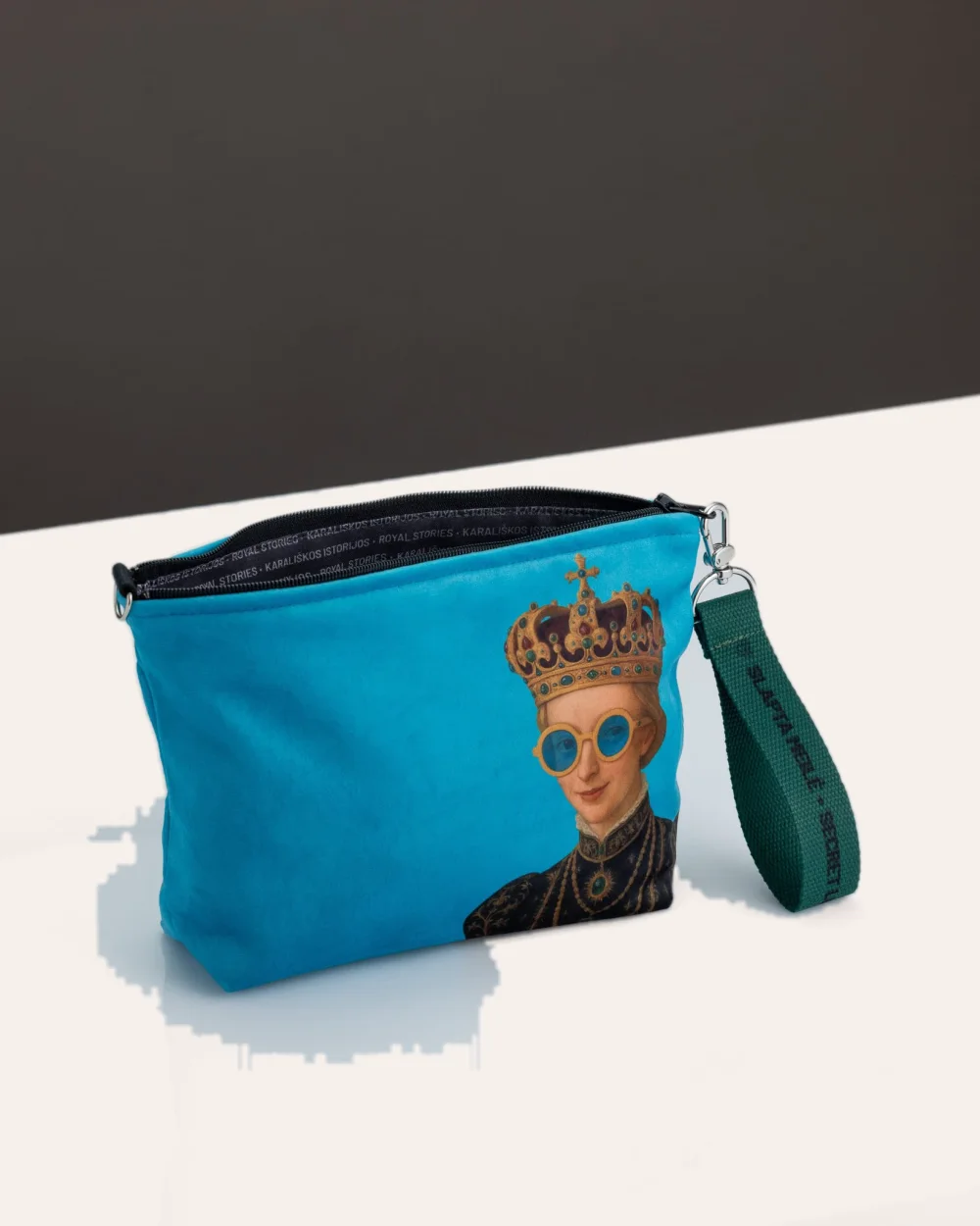 Atidaryta mėlyna kosmetinė „IMMIGRANT QUEEN: Sweden Edition“ su matomu tamsiu pamušalu