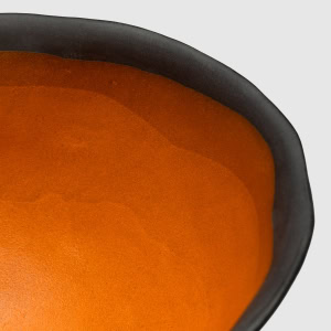 Karalių dubens ant kojelės oranžinės vidinės glazūros ir juodo krašto detalė iš arti