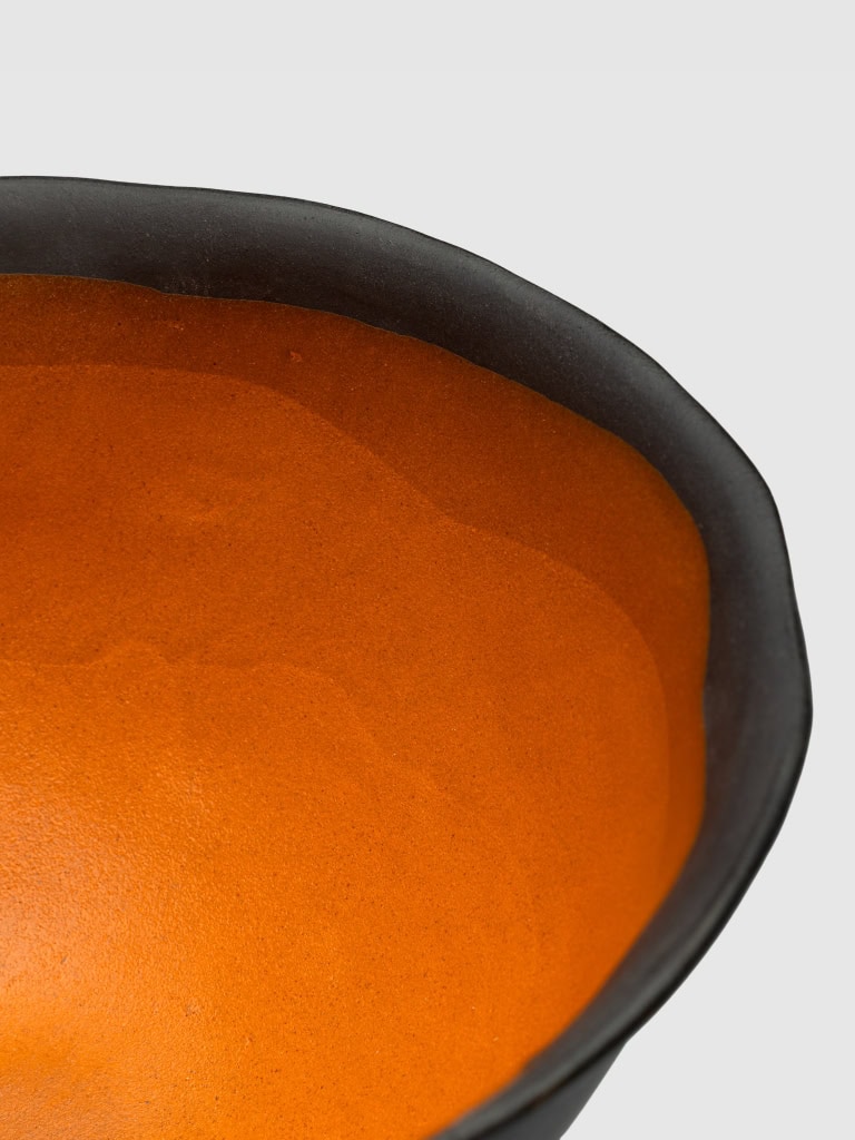 Karalių dubens ant kojelės oranžinės vidinės glazūros ir juodo krašto detalė iš arti