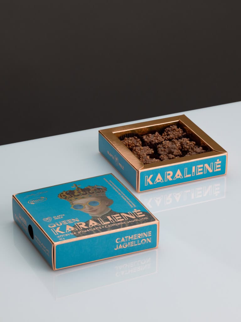 Dvi mėlynos saldainių „Karalienė Kotryna Jogailaitė“ dėžutės, viena su matomais saldainiais