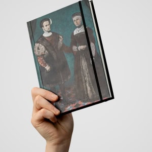 Užrašinė „Slapta meilė | Romantiškas Vilniaus miesto atodūsis“ su poros portretu, iškelta rankoje