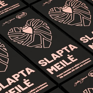 Daug pieninio šokolado „Slapta meilė“ juodų pakuočių su širdies piešiniu, išdėliotų eilėmis