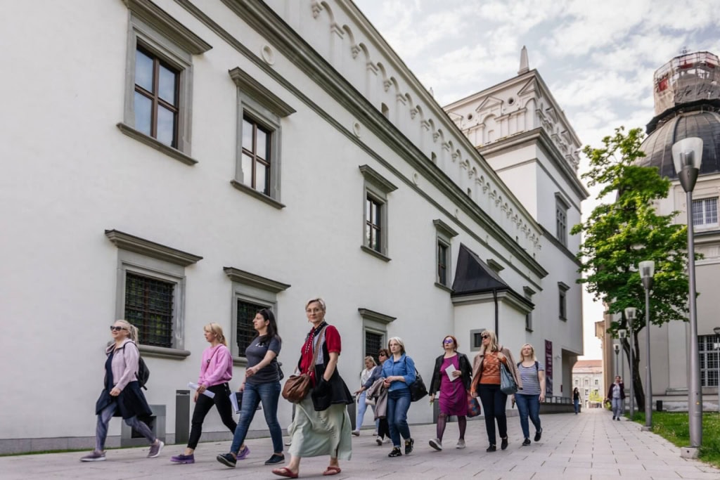 Ekskursijos grupė eina pro Valdovų rūmus Vilniuje – „Karališkos Vilniaus meilės istorijos“
