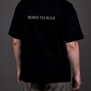 Juodų marškinėlių „KARŪNA“ nugara su užrašu „Born to rule“ ant vyro