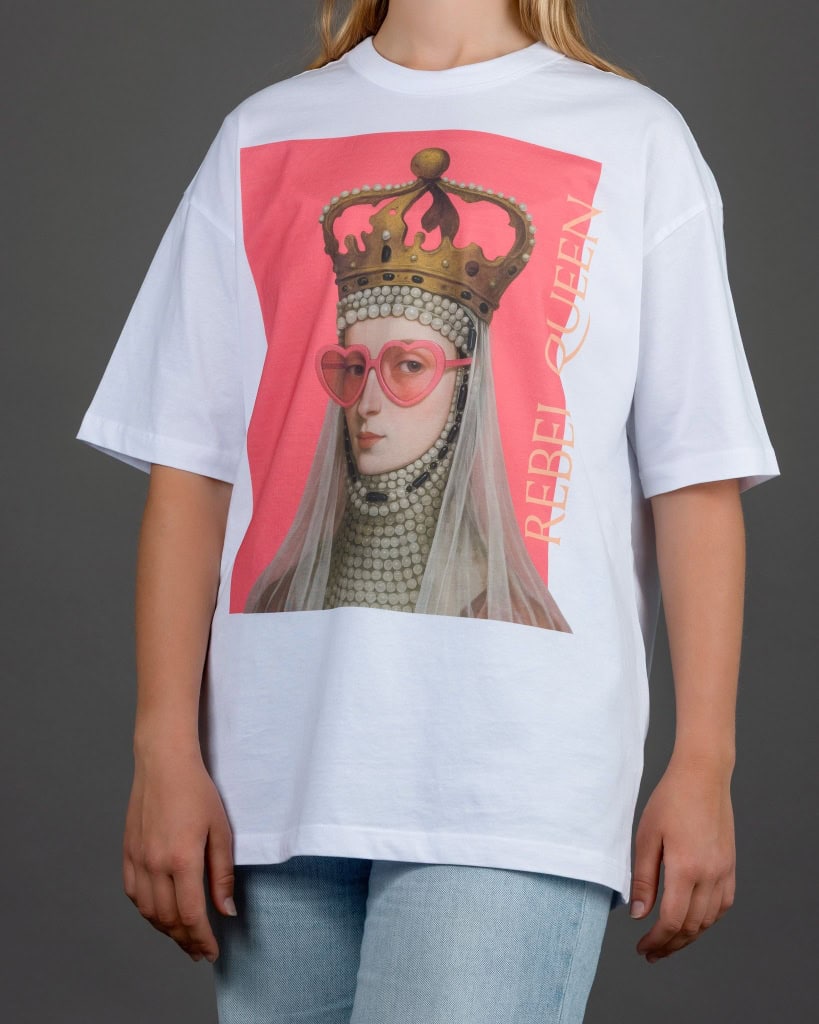 Moteris su baltais marškinėliais „REBEL QUEEN“ ir šviesiais džinsais, viso torso vaizdas