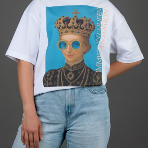 Moteris su baltais marškinėliais „IMIGRANT QUEEN / SWEDEN EDITION“, ranka už nugaros