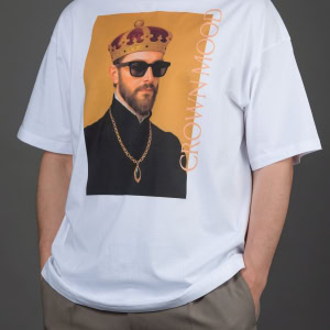 Vyras su baltais laisvo kirpimo marškinėliais „CROWN MOOD“ ir pilkomis kelnėmis