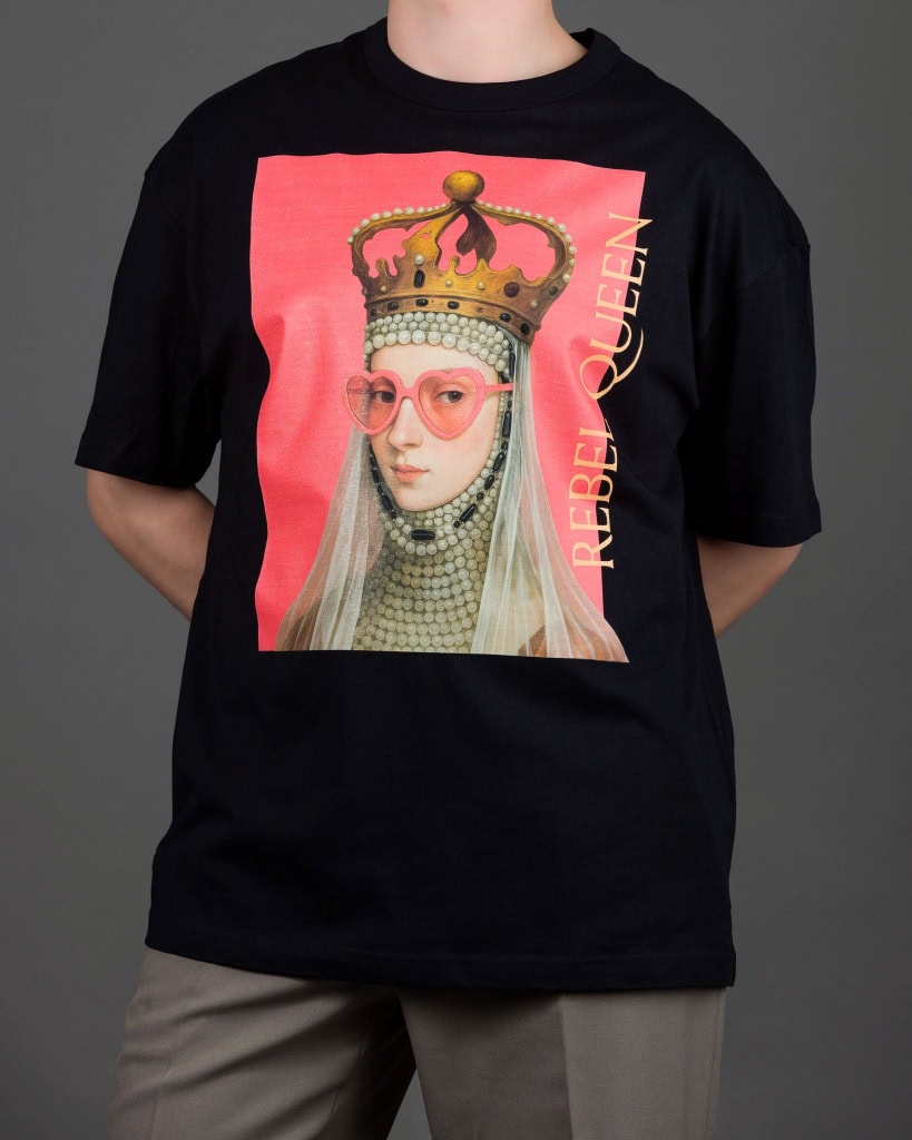 Vyras vilki juodus marškinėlius „REBEL QUEEN“ su karalienės portretu, rankos už nugaros