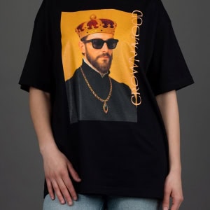 Moteris su juodais marškinėliais „CROWN MOOD“ ir šviesiais džinsais iš priekio