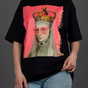 Moteris su juodais marškinėliais „REBEL QUEEN“ ir džinsais, rankos nuleistos