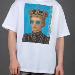 Vyras su baltais marškinėliais „IMIGRANT QUEEN / SWEDEN EDITION“, rankos nuleistos