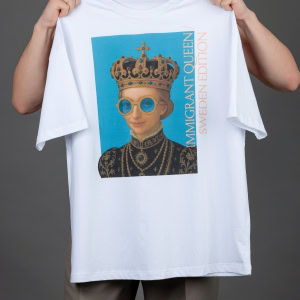 Vyras laiko iškėlęs baltus marškinėlius „IMIGRANT QUEEN / SWEDEN EDITION“ prieš save