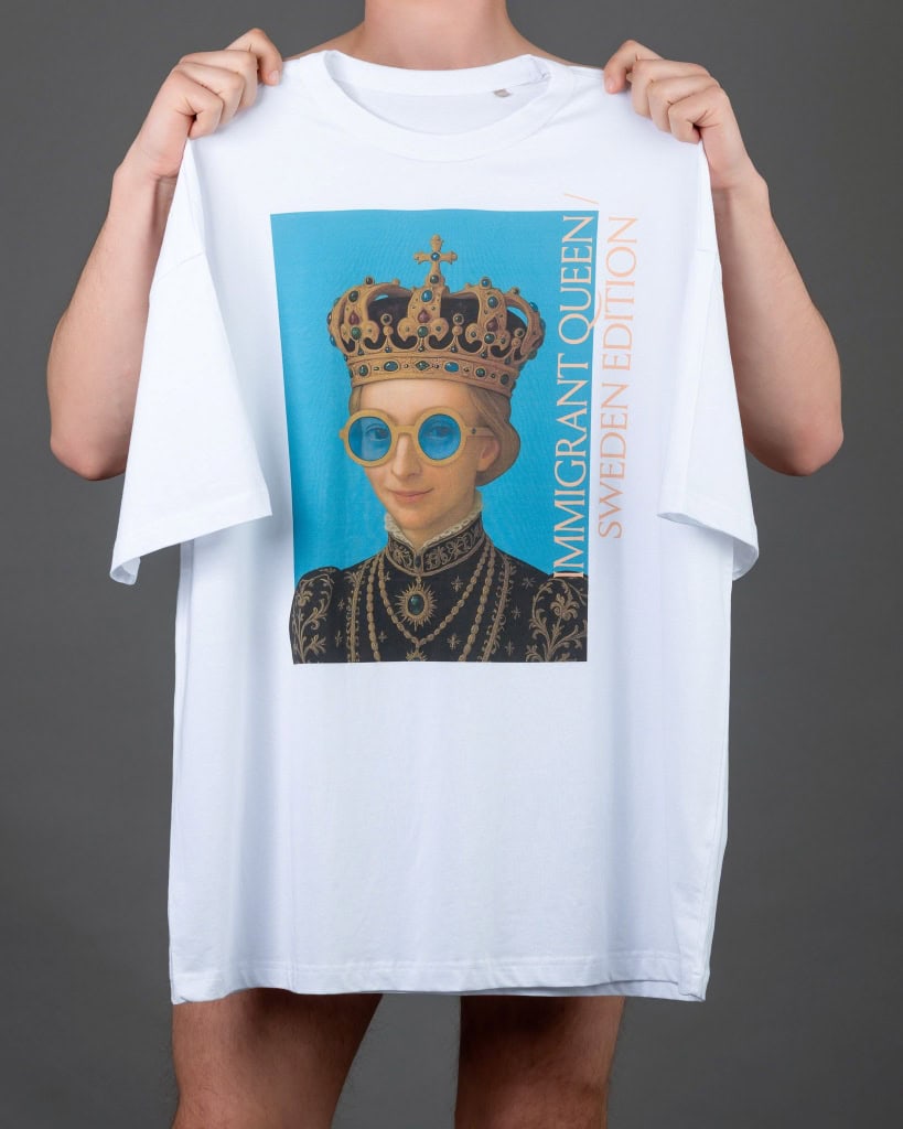Rankose ištiesti balti marškinėliai „IMIGRANT QUEEN / SWEDEN EDITION“ su karalienės portretu