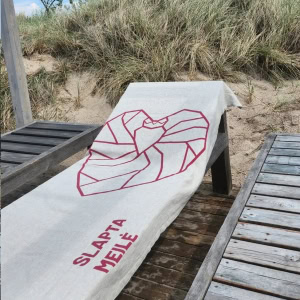 Pilkas lininis rankšluostis „Karaliaus“ su raudonu širdies piešiniu ant gulto kopose