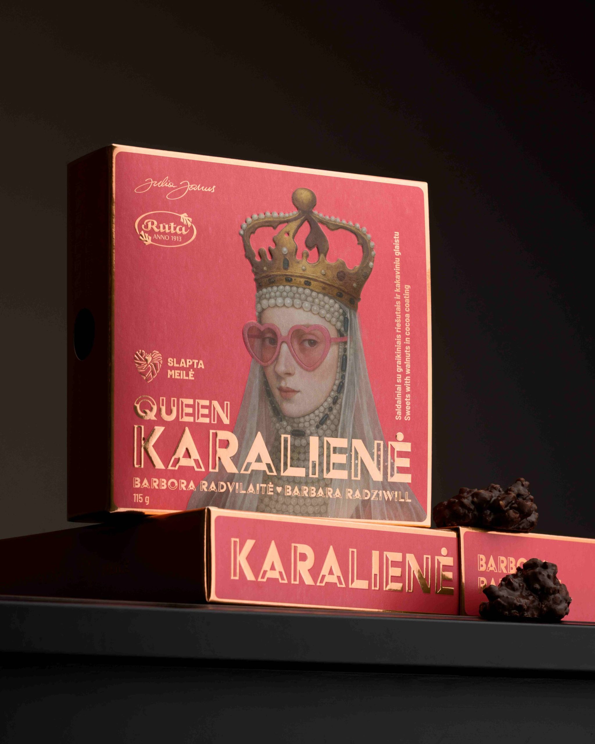 Rožinė saldainių dėžutė „Queen Karalienė“ su karalienės portretu tamsiame fone