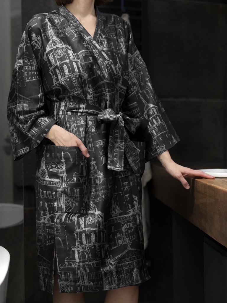 Modelė antracito chalatu kimono „Karališko Vilniaus meilės istorija“ vonioje prie stalviršio, priekis