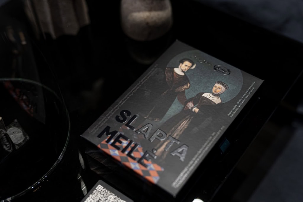 Tamsi saldainių dėžutė „Slapta meilė“ su renesanso poros portretu tamsiame fone