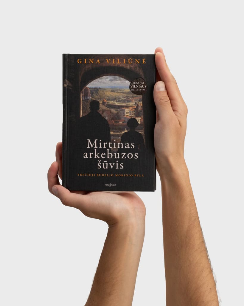 Ranka laiko Gina Viliūnė knygą „Mirtinas arkebuzos šūvis“, matomas priekinis viršelis