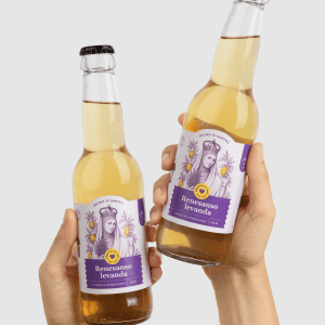 Dvi rankos laiko du limonado „Renesanso levanda“ butelius tarsi sudaužiant