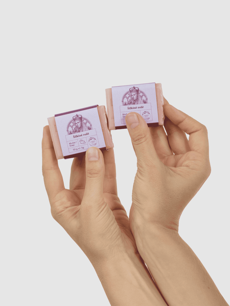 Dvi rankos laiko du mažus kieto muilo „Šilkinė rožė“ 50 g gabalėlius
